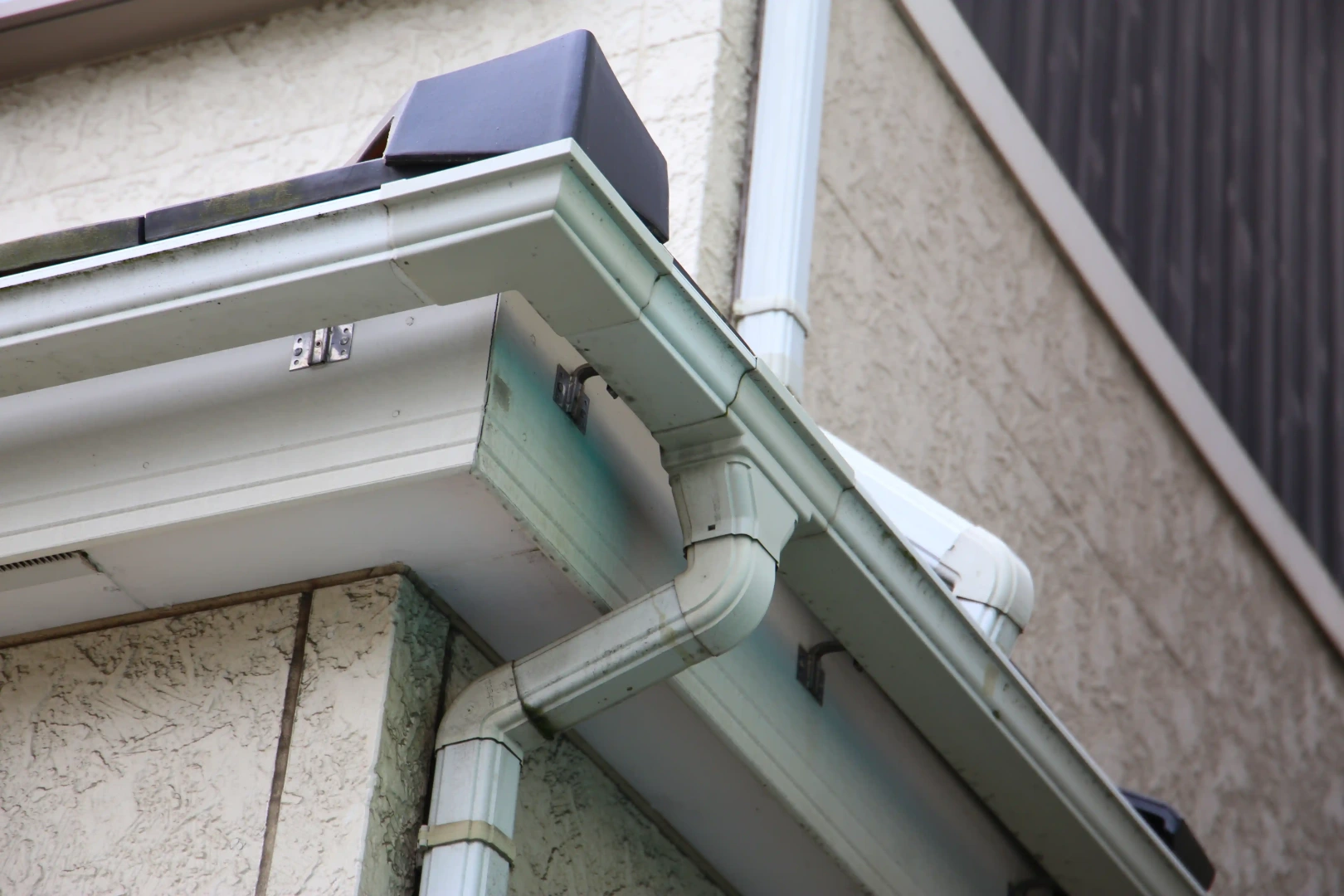 Close view of a residential gutter and downspout corner
